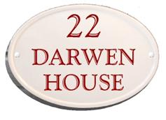 oval house sign with burgundy writing